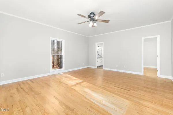 a view of an empty room with a window and a ceiling fan