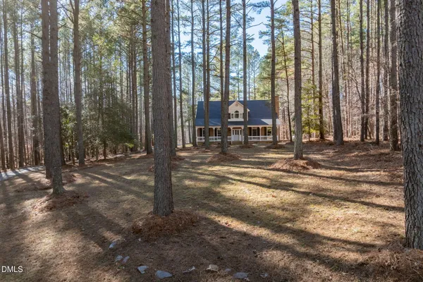 a wooden house with trees in the background