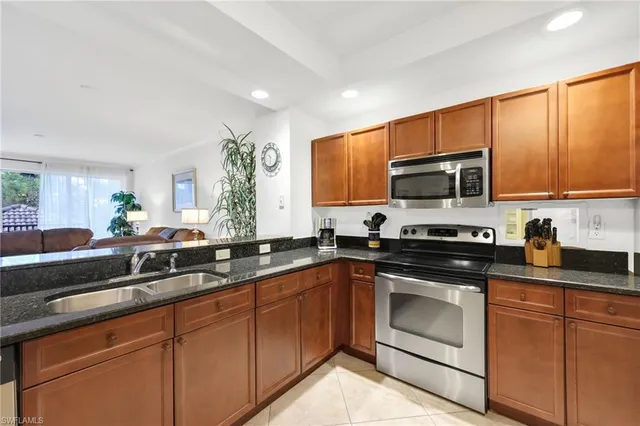 a kitchen with sink a microwave and cabinets