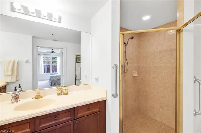 a bathroom with a shower sink vanity and mirror