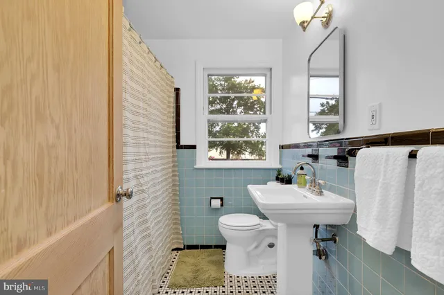 a bathroom with a sink toilet and a window