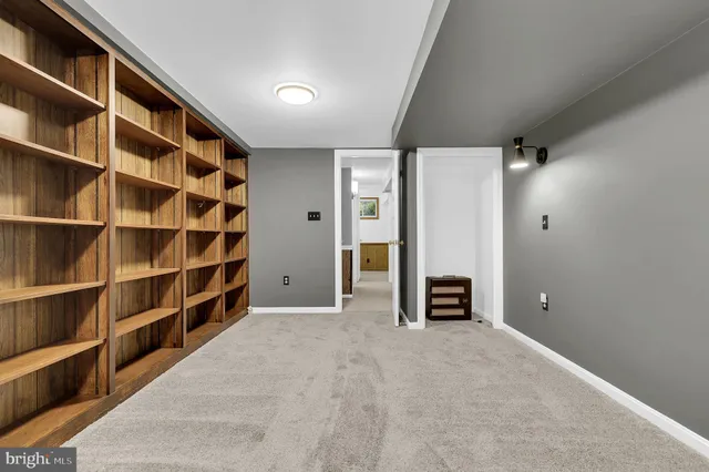 a view of an empty room with cabinet and a window