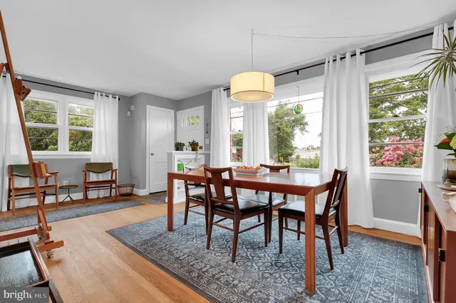 a dining room with wooden floor a chandelier a wooden table and chairs