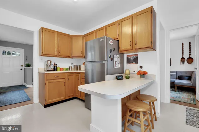 a kitchen with a sink a refrigerator and cabinets