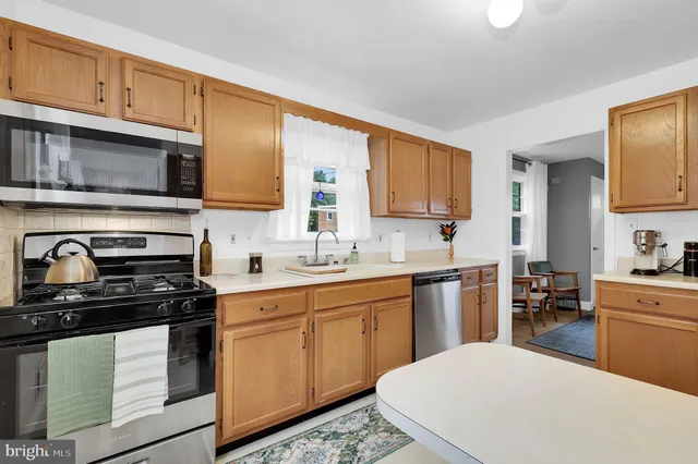 a kitchen with stainless steel appliances a stove sink microwave and cabinets
