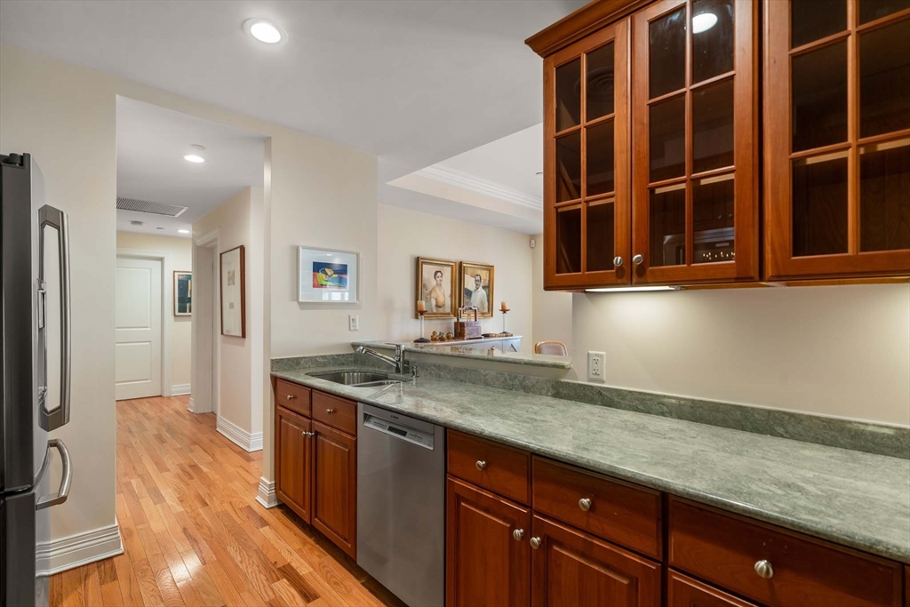 630 Hammond Street, Unit 102 Brookline, MA 02467 - Photo 11 of 19 a kitchen with stainless steel appliances granite countertop a sink and a refrigerator
