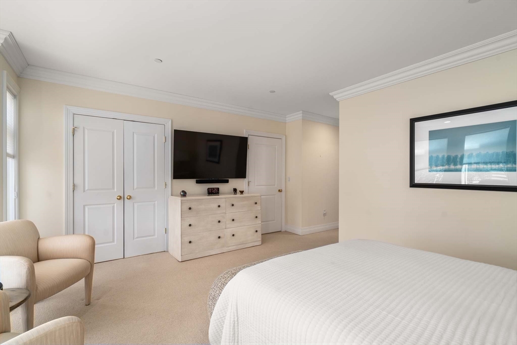 630 Hammond Street, Unit 102 Brookline, MA 02467 - Photo 13 of 19 a bedroom with a bed and a flat screen tv