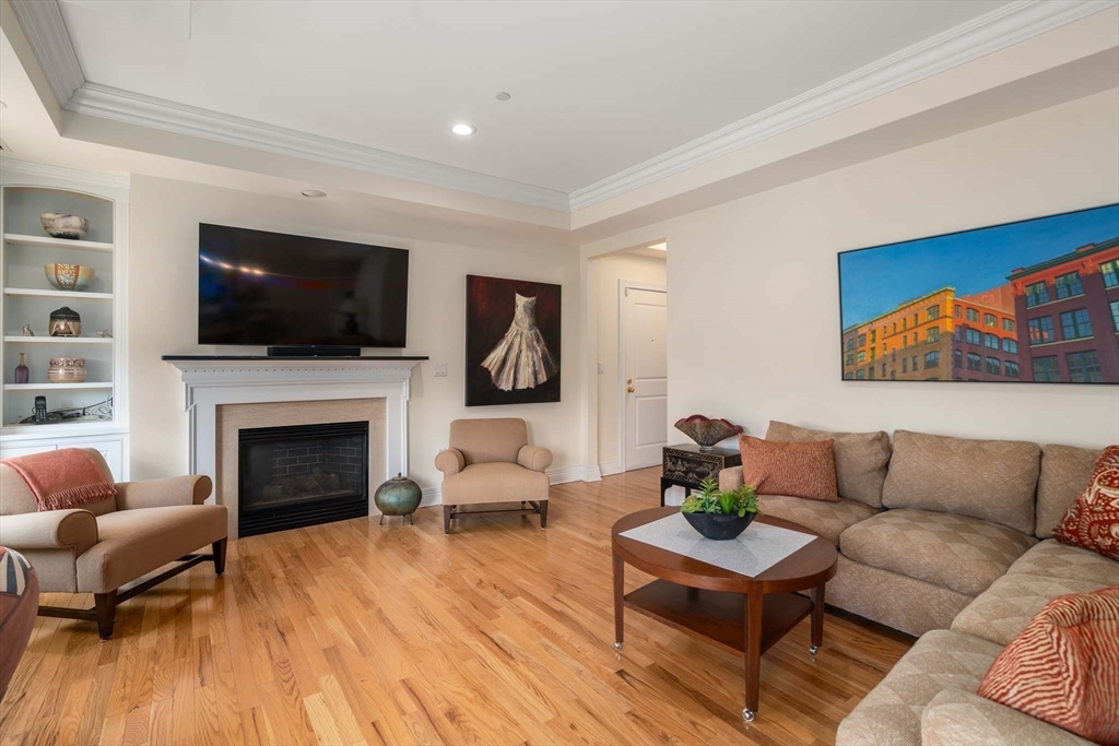 630 Hammond Street, Unit 102 Brookline, MA 02467 - Photo 5 of 19 a living room with furniture a flat screen tv and a fireplace