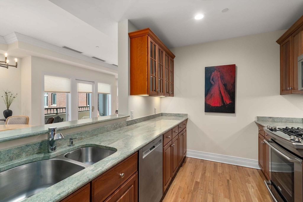 630 Hammond Street, Unit 102 Brookline, MA 02467 - Photo 9 of 19 a kitchen with stainless steel appliances granite countertop a sink stove and cabinets