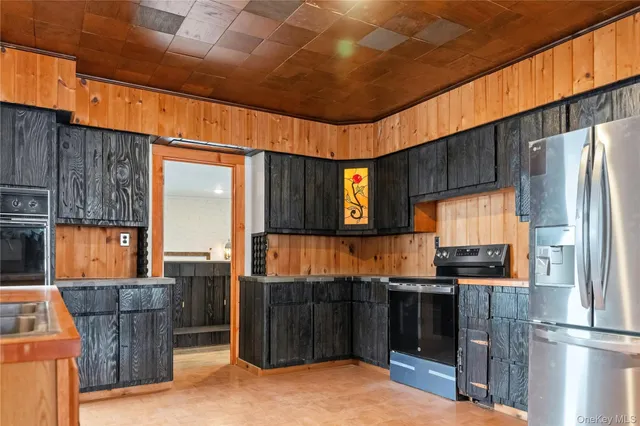 a kitchen with stainless steel appliances kitchen island granite countertop a refrigerator a stove and a sink