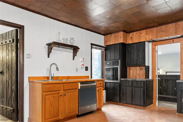 a room with stainless steel appliances kitchen island granite countertop a refrigerator and a sink