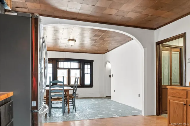 a view of a hallway with wooden furniture and windows