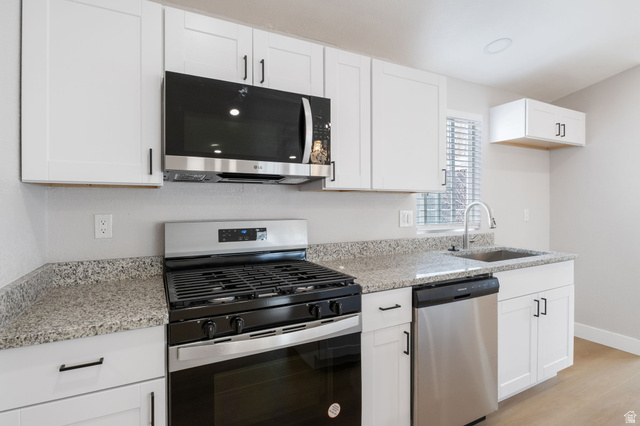 332 Hillgate Way Layton, UT 84041 - Photo 3 of 26 Kitchen featuring stainless steel appliances, white cabinets, light stone countertops, and light wood-style flooring