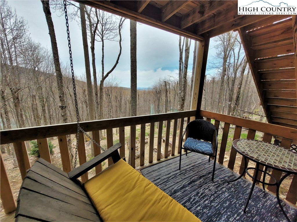 143 Tamarack Road Beech Mountain, NC 28604 - Photo 25 of 47 a balcony with wooden floor table and chairs