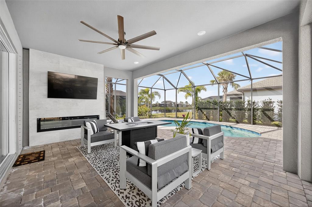 17744 Savory Mist Circle Lakewood Ranch, FL 34211 - Photo 3 of 55 a living room with couch a flat screen tv and a floor to ceiling window