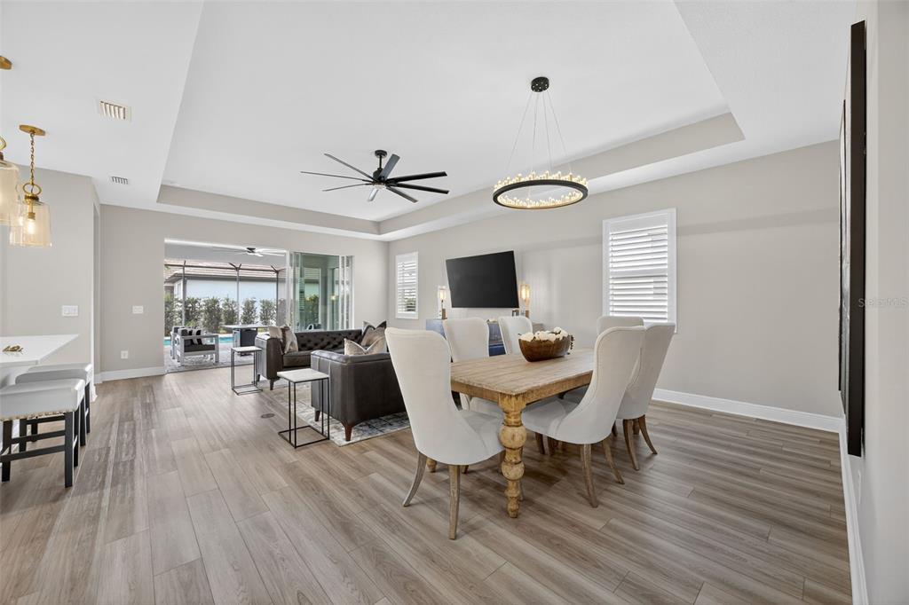 17744 Savory Mist Circle Lakewood Ranch, FL 34211 - Photo 8 of 55 a view of a dining room with furniture window and wooden floor