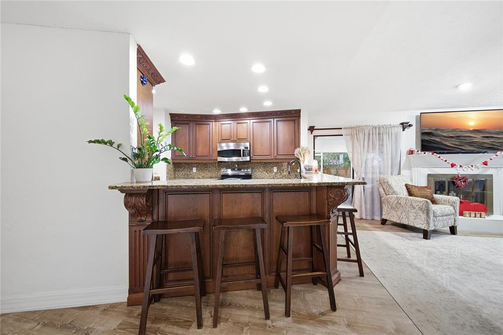 4602 Buckeye Road Tampa, FL 33624 - Photo 14 of 36 a kitchen with stainless steel appliances kitchen island granite countertop a refrigerator and a stove top oven