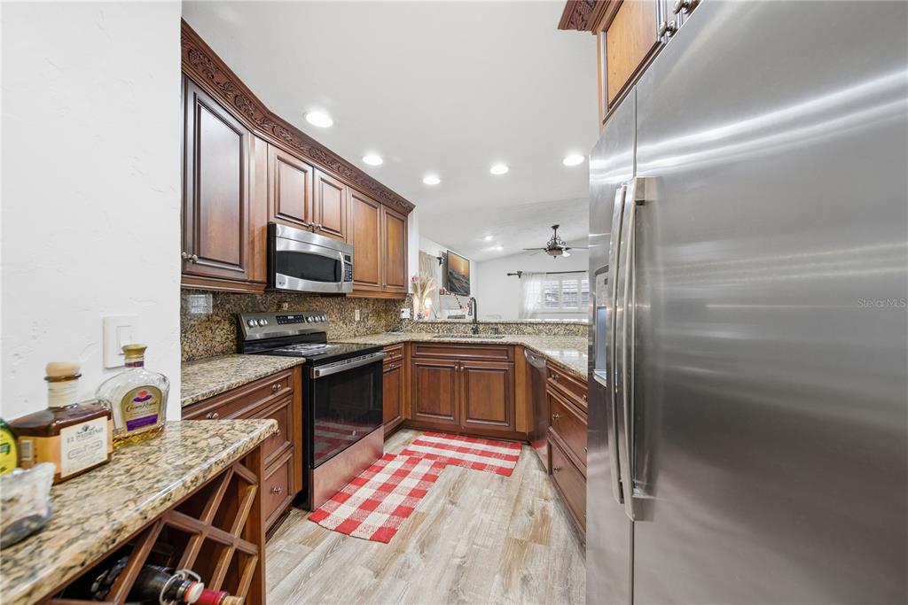 4602 Buckeye Road Tampa, FL 33624 - Photo 16 of 36 a kitchen with granite countertop stainless steel appliances and wooden cabinets