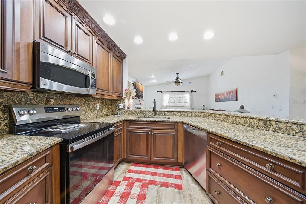 4602 Buckeye Road Tampa, FL 33624 - Photo 18 of 36 a kitchen with stainless steel appliances granite countertop sink stove and cabinets