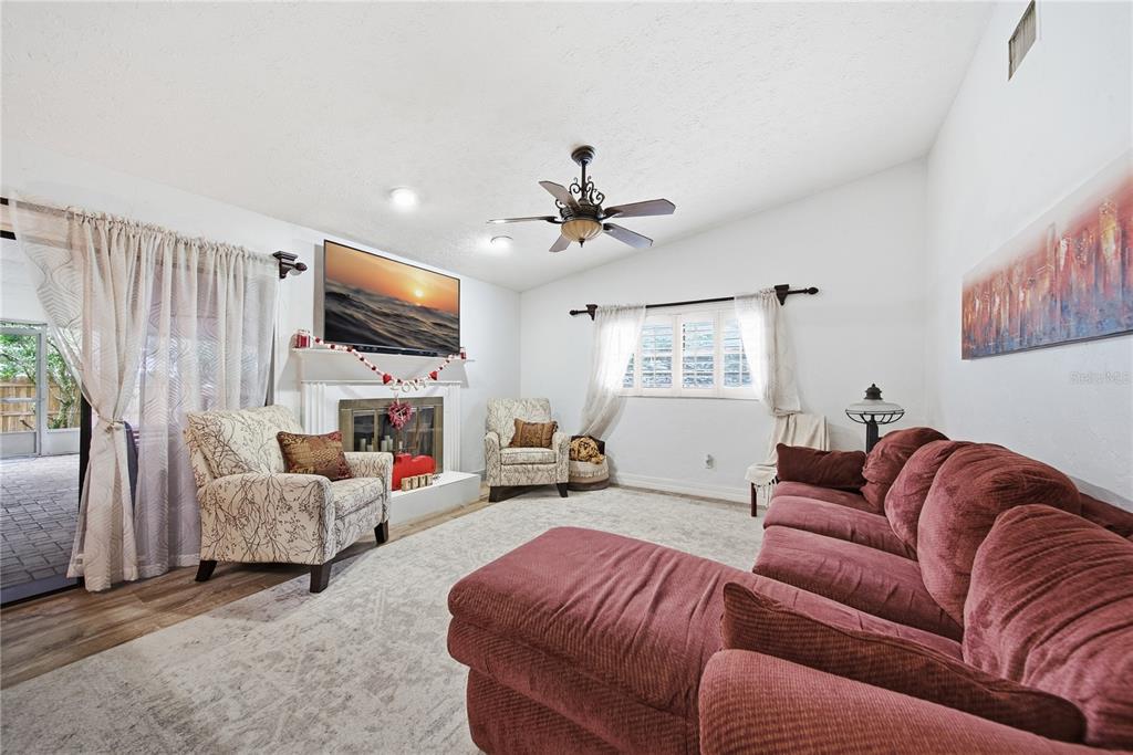 4602 Buckeye Road Tampa, FL 33624 - Photo 19 of 36 a living room with furniture a fireplace and a flat screen tv