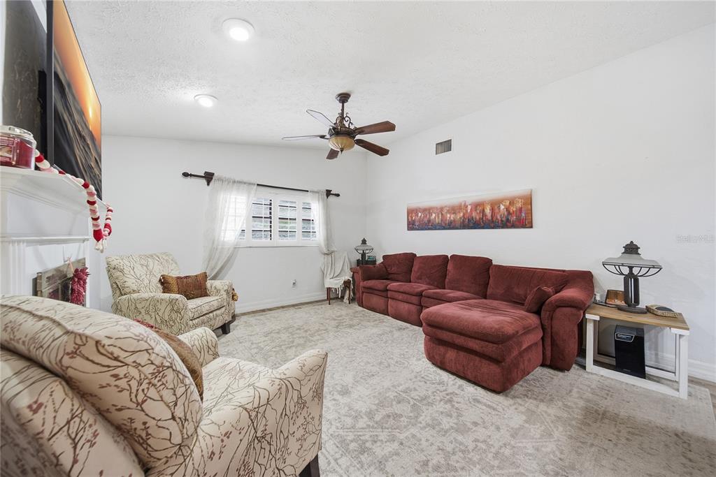 4602 Buckeye Road Tampa, FL 33624 - Photo 21 of 36 a bedroom with a bed a couch and a chandelier