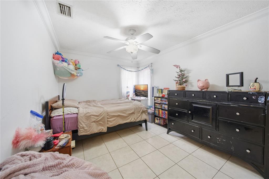 4602 Buckeye Road Tampa, FL 33624 - Photo 24 of 36 a bedroom with a bed and a chandelier