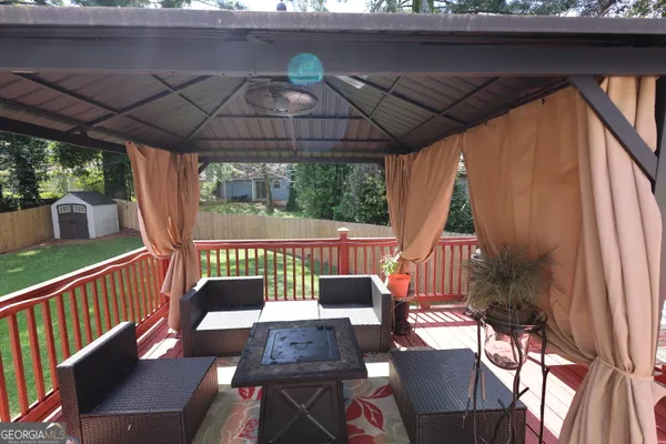 a view of a patio with a table chairs and a barbeque