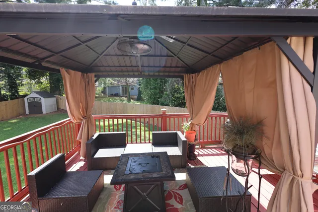 a view of a patio with a table chairs and a barbeque