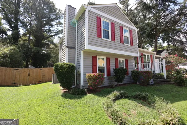 a front view of a house with a yard and plants
