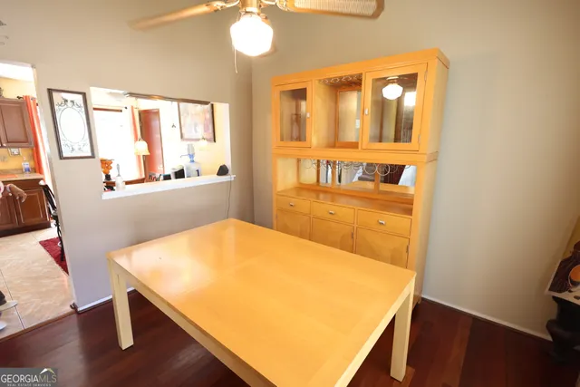 a view of a room with wooden floor windows and a kitchen view