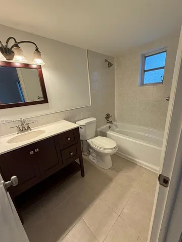 a spacious bathroom with a double vanity sink a toilet and a mirror