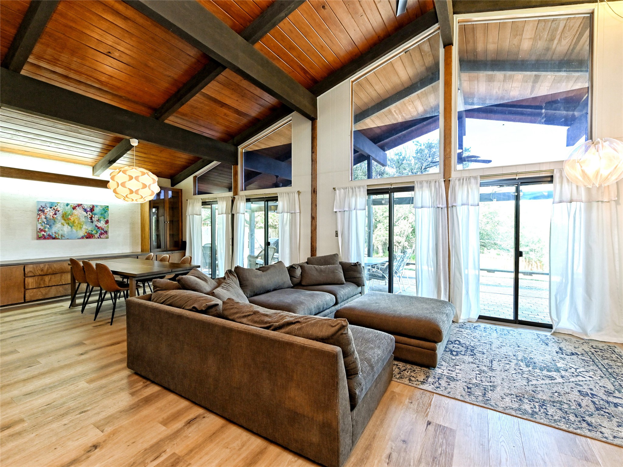 115 Snapper Street Lakeway, TX 78734 - Photo 5 of 30 A spacious living area with soaring wooden ceilings and an abundance of natural light through expansive windows.
