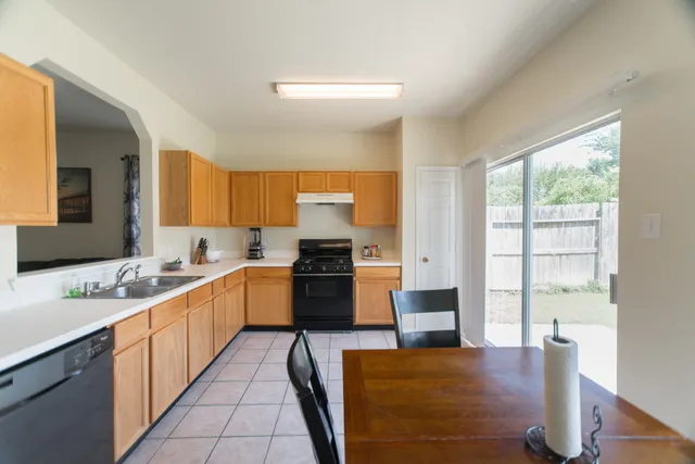 a large kitchen with stainless steel appliances granite countertop a stove a sink and a refrigerator