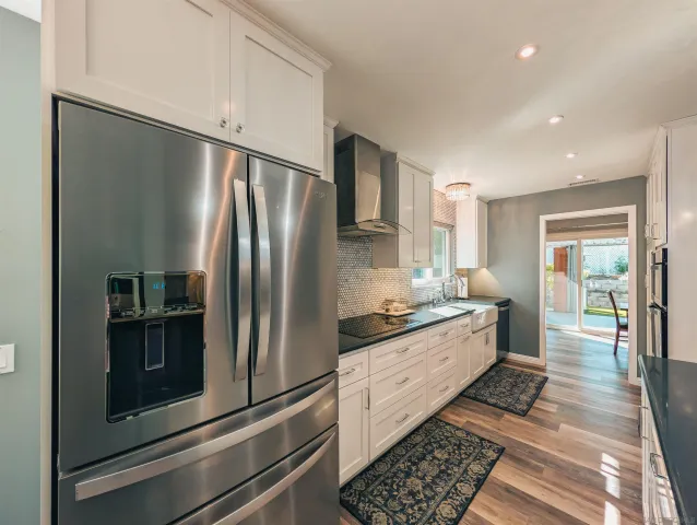 a kitchen with stainless steel appliances granite countertop a refrigerator and a stove