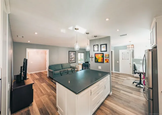 a kitchen with stainless steel appliances granite countertop a refrigerator a stove and a sink