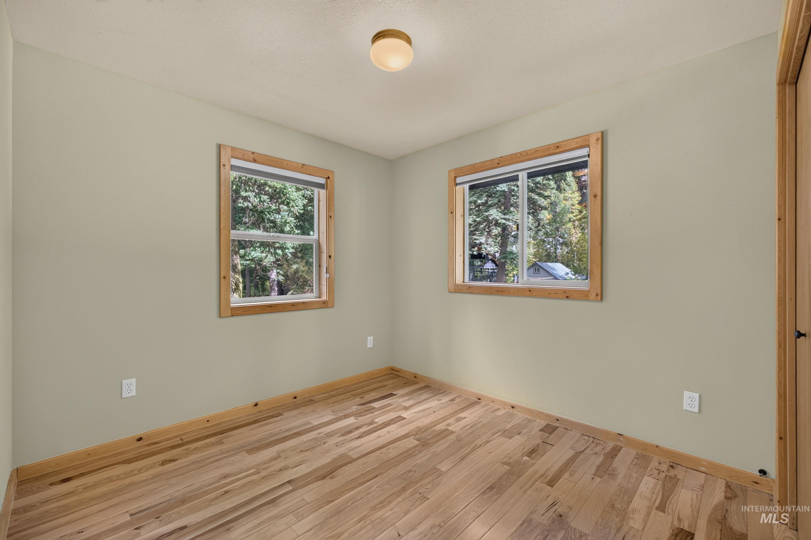 3531 Kp Cove Road McCall, ID 83638 - Photo 28 of 49 Natural wood-finish flooring, light-colored walls, and two windows with natural wood trim