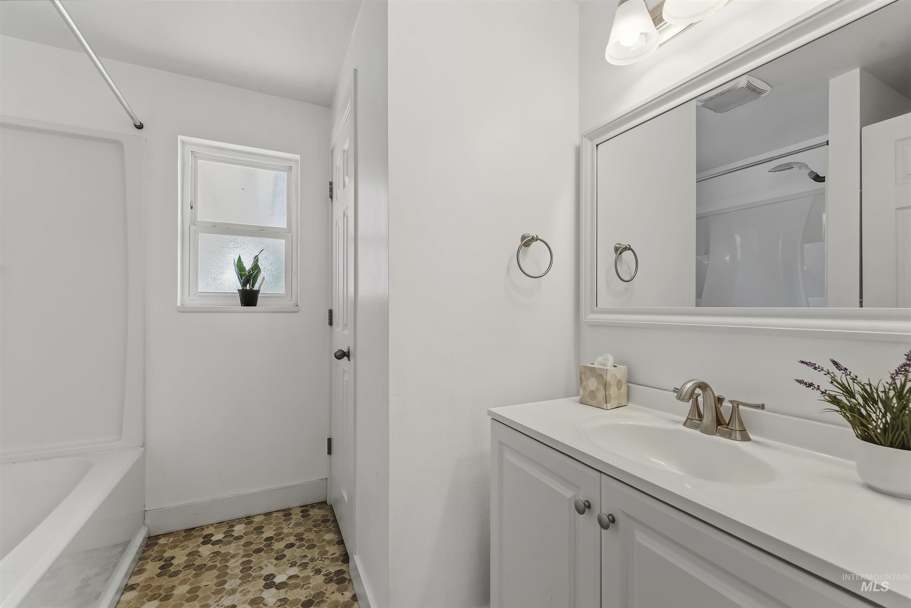 355 East Beacon Light Road Eagle, ID 83616 - Photo 21 of 47 Bathroom vanity featuring a white countertop with an undermount sink and brushed nickel faucet