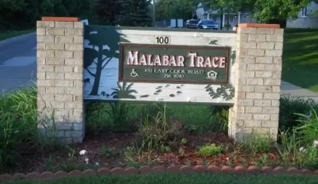 a sign that is sitting in front of flowers