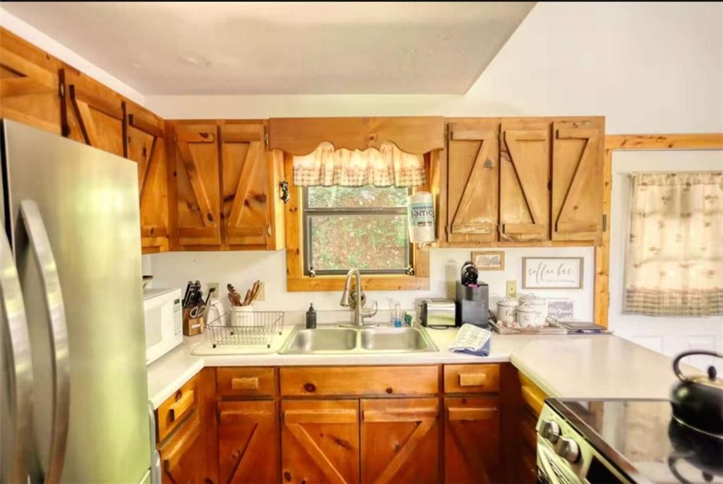 2531 Hunter Road Hiawassee, GA 30546 - Photo 25 of 30 a kitchen with stainless steel appliances a sink a refrigerator and a counter space