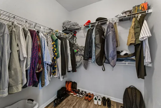 a view of walk in closet with clothes and shoes