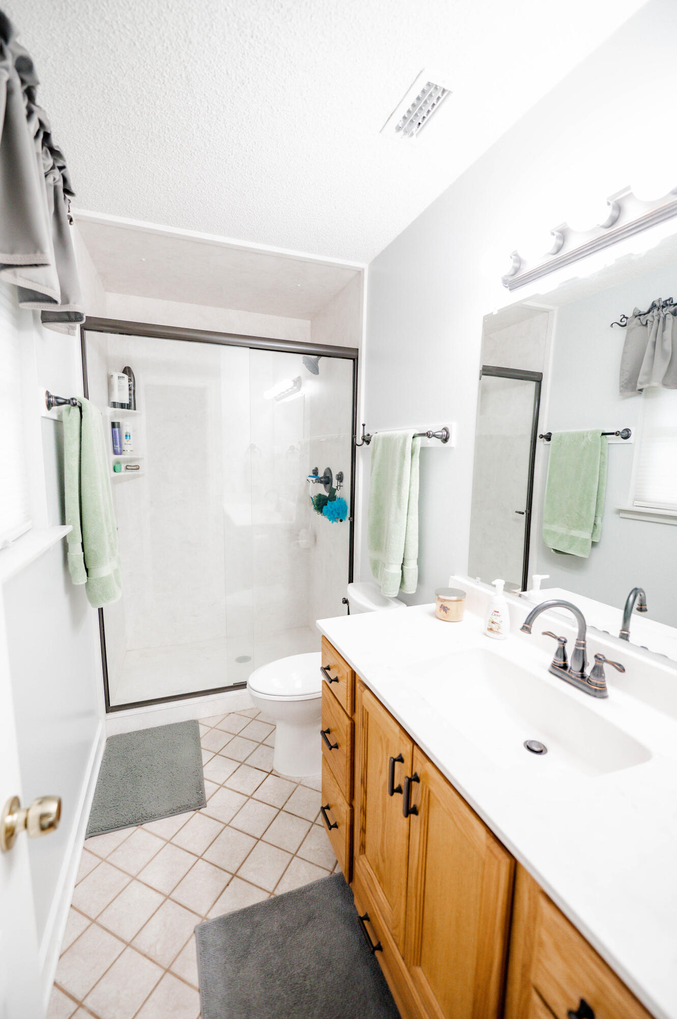 218 Howard Street Niceville, FL 32578 - Photo 23 of 36 a bathroom with a sink a mirror and a shower