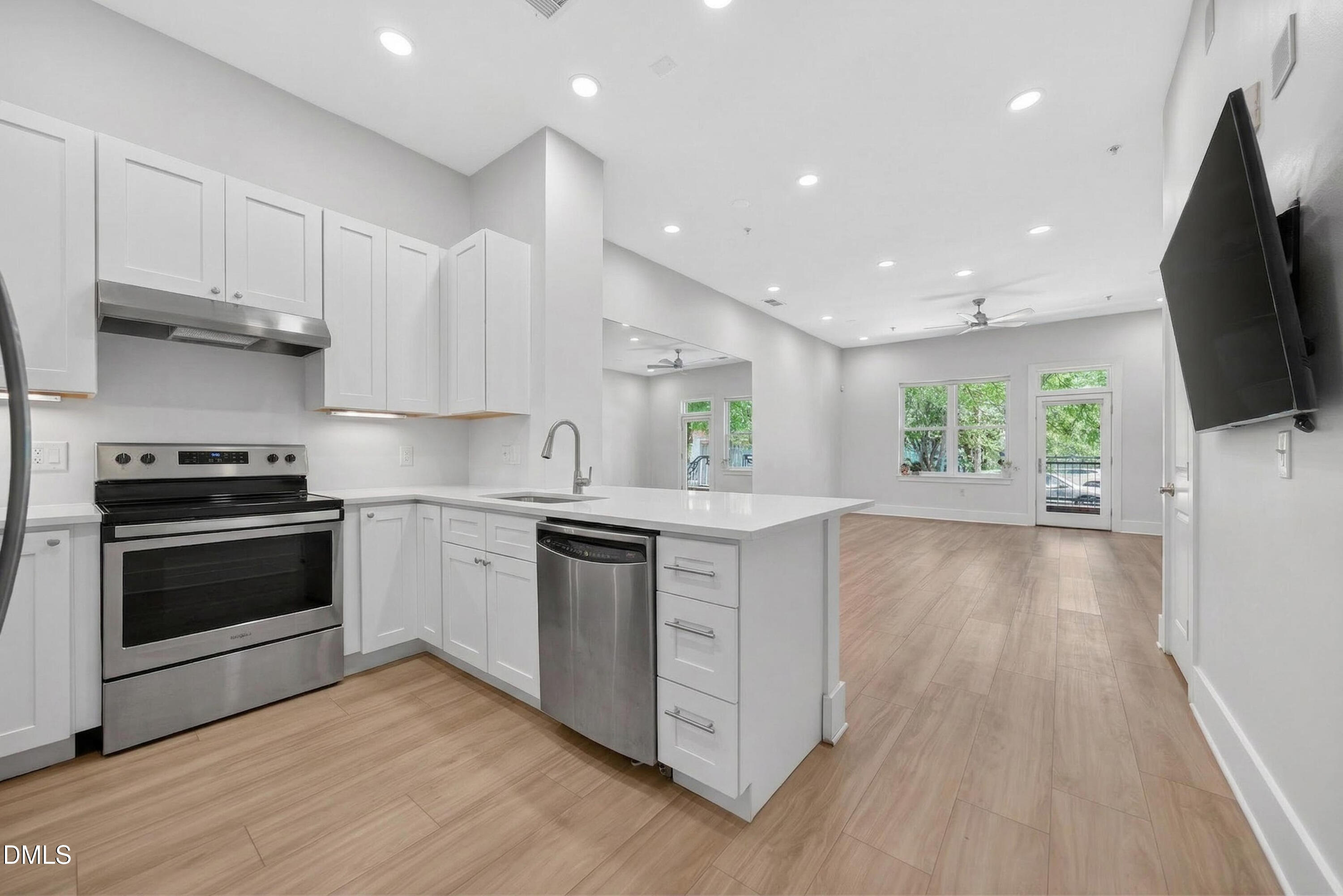 444 South Blount Street, Unit 111 Raleigh, NC 27601 - Photo 6 of 40 a kitchen with stainless steel appliances a stove a sink a microwave a refrigerator and cabinets