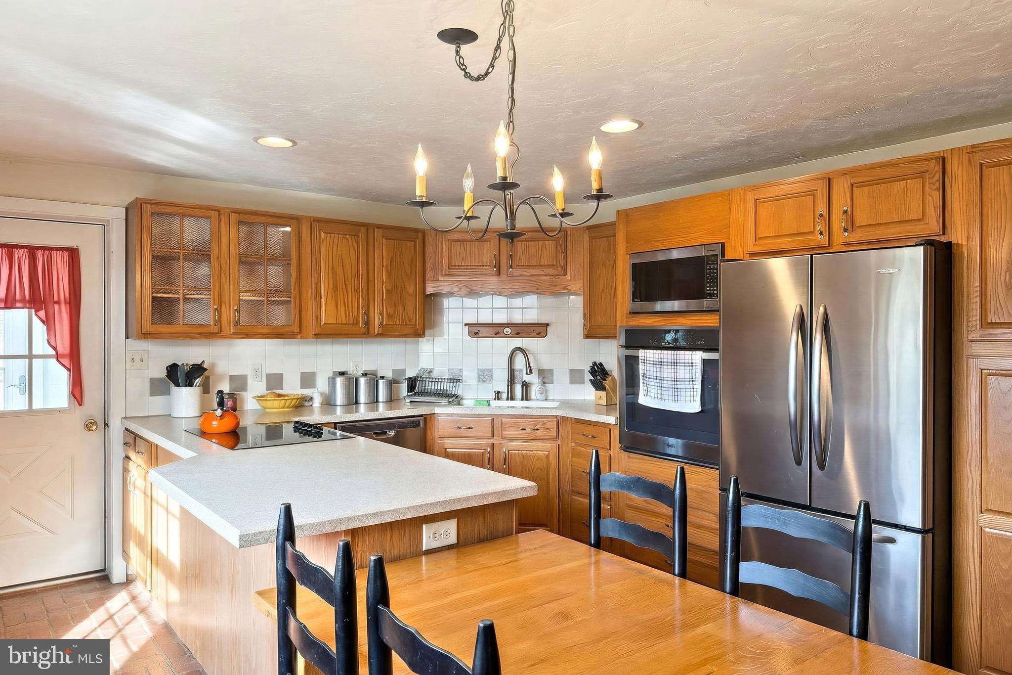 625 Mt Tabor Road Gardners, PA 17324 - Photo 16 of 63 a kitchen with granite countertop a refrigerator a sink dishwasher a stove and a dining table with wooden floor