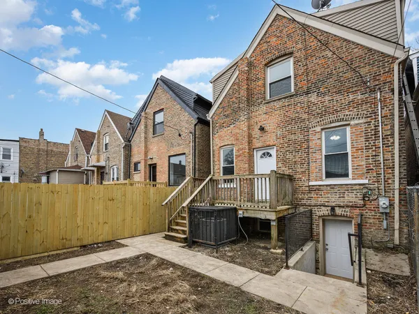 a view of a house with a small yard and wooden fence