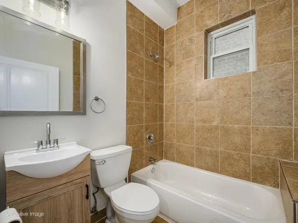 a bathroom with a toilet a sink a mirror a bathtub and shower