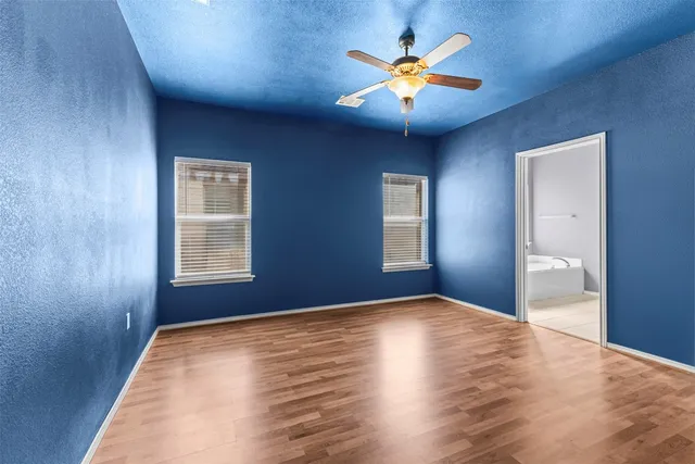a view of empty room with chandelier fan and window