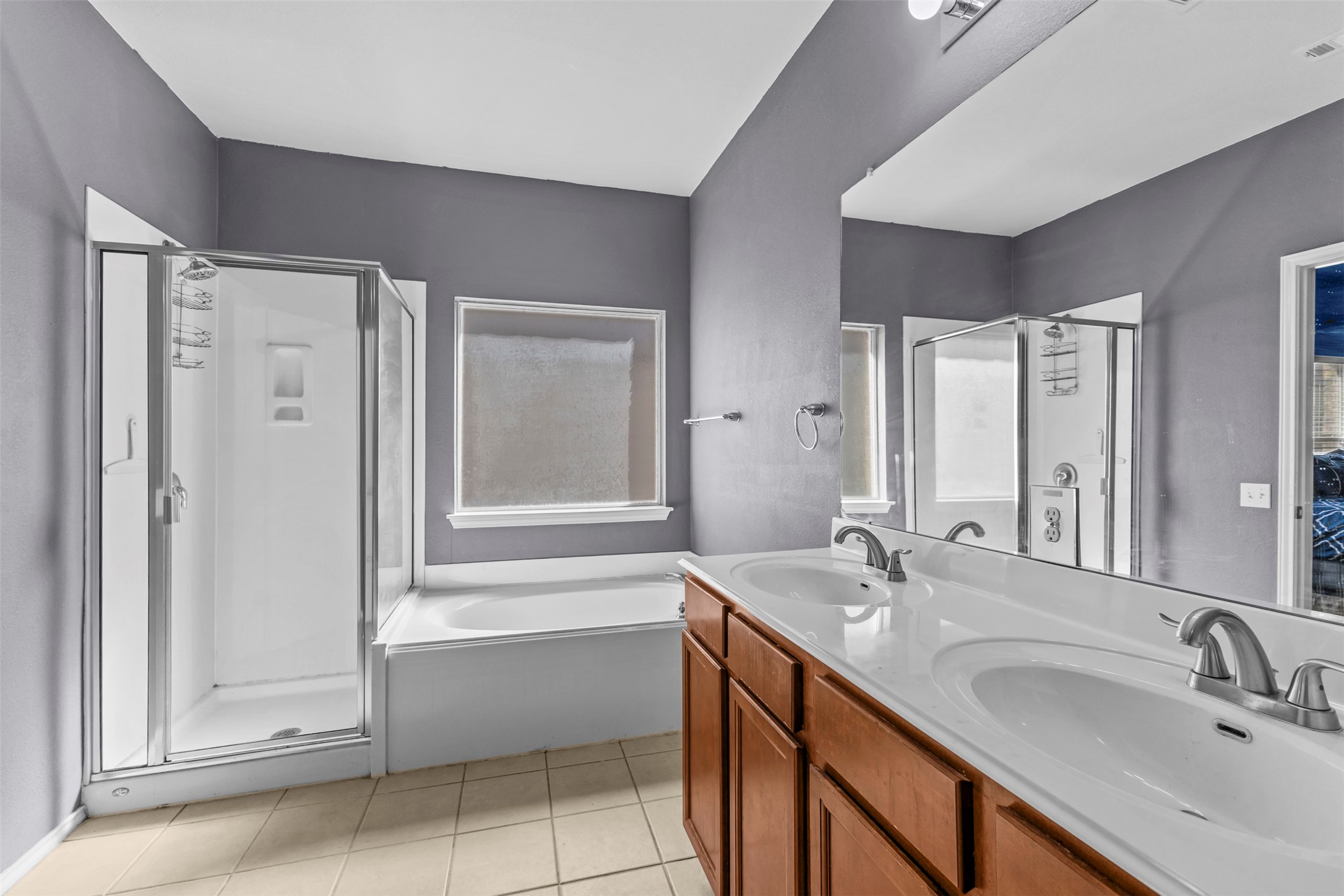 5709 Zachary Scott Street Austin, TX 78747 - Photo 13 of 29 a bathroom with a double vanity sink a mirror and a bathtub