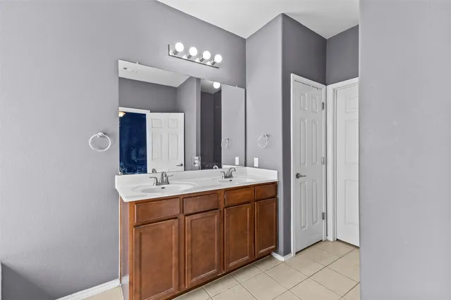 a bathroom with a double vanity sink and a mirror