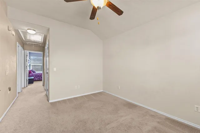 an empty room with a ceiling fan and window