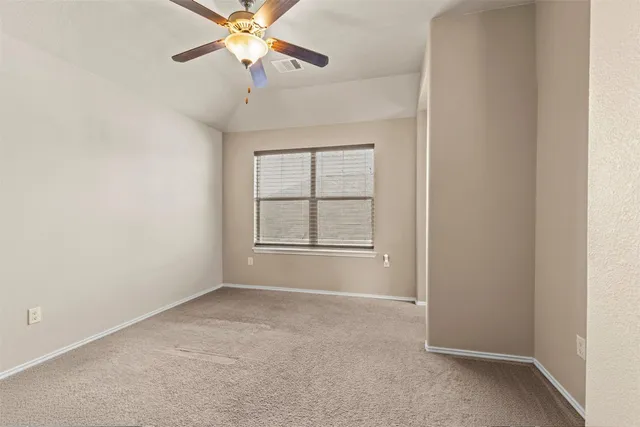 an empty room with windows and fan